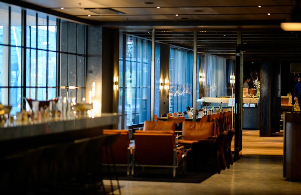 Restaurangmiljö på At Six med sittplatser längs fönstren